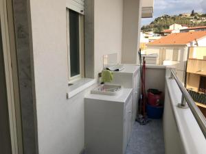 a bathroom with a sink and a window on a balcony at casa vacanze La Formica in Capo dʼOrlando