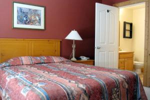 a bedroom with a bed with a red wall at Cornerstone Lodge by Park Vacation Management in Fernie
