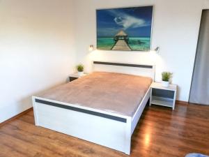 uma cama branca num quarto com uma pintura na parede em Apartament na Wolanach em Polanica-Zdrój