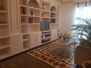 a living room with white shelves and a television at Apartamento centro frente a Torres de Serrano in Valencia