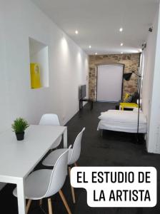 a room with a bed and a table and chairs at El Estudio de La Artista - El casar de Leo in Alburquerque