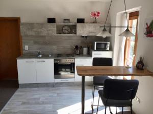 a kitchen with a wooden table and a table and chairs at Ferienwohnung Maintal Würzburg in Würzburg