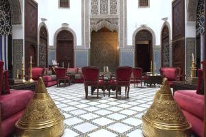 a room with chairs and a table in a building at La Maison Bleue Batha in Fez