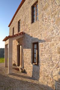 a stone building with a door and windows on it at Casa da Trapa in Oliveira de Azemeis
