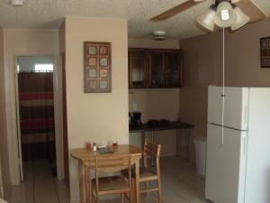 a kitchen with a table and a white refrigerator at Newly Furnished Large, Clean, Quiet Private Unit in Fort Lauderdale