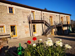 Montabone的住宿－Casa Re - B&B e Vino a Montabone，石头建筑,前面有楼梯和鲜花