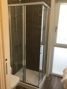 a shower with a glass door in a bathroom at GoodStay New City Apartment (monolocale) in Lecce +24 photos