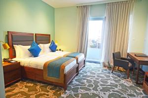 a hotel room with a bed and a desk and a window at Ocean Edge Suites & Hotel Colombo in Colombo