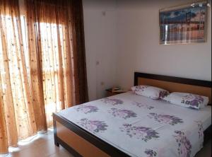 a bedroom with a bed with a floral bedspread at Ksamil Apartments in Ksamil