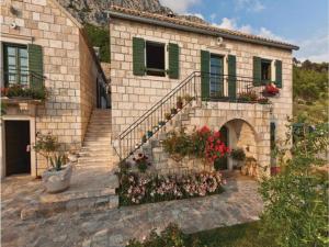 a stone house with stairs and flowers in front of it at Holiday House Brela in Brela