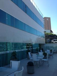 une rangée de tables et de chaises devant un bâtiment dans l'établissement Hotel Litoral Fortaleza, à Fortaleza