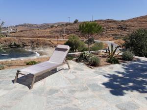 una sedia bianca seduta su un patio in pietra di Villa Ligia Beach a Koundouros