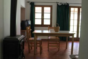 salon ze stołem, krzesłami i kuchenką w obiekcie Pian del Noce w mieście Magliano in Toscana