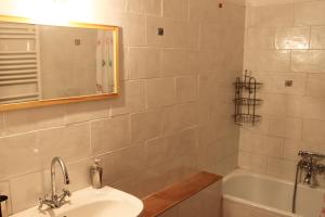 y baño con lavabo, bañera y espejo. en Pian del Noce en Magliano in Toscana