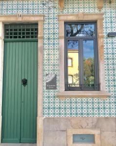 una puerta verde y una ventana en un edificio en HOSTEL ALAMEDA EXCLUSIVE HOUSE en Faro