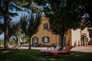 フラスカーティにあるメルマリア ワイン リゾートの庭に椅子2脚とテーブル1台がある家