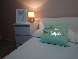 un letto con un cuscino con un cartello sopra di Aquamarine apartment a Spalato (Split)