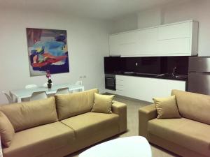 a living room with a couch and a kitchen at Residenca Juli in Vlorë