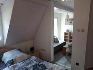 een slaapkamer met een bed en een bank in een kamer bij Gemuetliche Eule in Waischenfeld