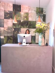 HOSTEL ALAMEDA EXCLUSIVE HOUSE في فارو: امرأة تجلس في مكتب ومع جهاز كمبيوتر محمول