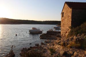 una barca in acqua accanto a un edificio di Holiday home - Villa Bianca a Stari Grad (Cittavecchia)