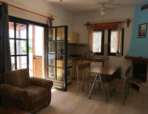 a living room with a table and a kitchen at Oliaria Apartments in Platanias