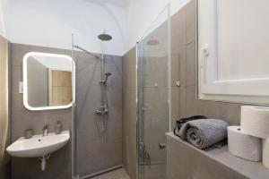 een badkamer met een douche, een wastafel en een spiegel bij Astoria Flats 1 in Boedapest