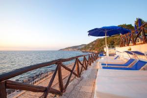 einen Strand mit Sonnenschirm und das Meer in der Unterkunft Hotel Piccolo Paradiso in Massa Lubrense