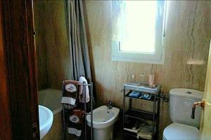 a small bathroom with a toilet and a sink at El Rincón de las Marismas in Carasa +33 photos