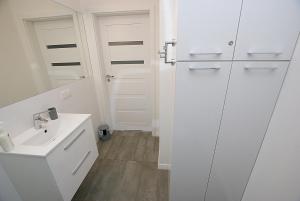 a white bathroom with a sink and a mirror at Apartament Sweet Home Pogorzelica in Pogorzelica +24 photos