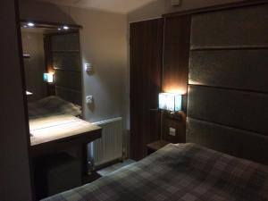 1 dormitorio con cama, escritorio y espejo en Silver Woods Reighton Sands, en Filey
