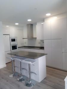 a kitchen with white cabinets and a table in it at Beach House in Puerto de Mazarrón