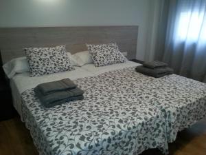 ein großes Bett mit zwei Kissen darüber in der Unterkunft Edificio Tiziano Mercado Central in Valencia
