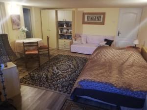 ein Schlafzimmer mit einem Bett, einer Couch und einem Tisch in der Unterkunft Royal Court Apartman - HU registered IntStud Apartman in Szekszárd