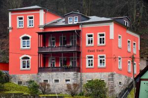 un edificio rojo con un letrero que dice guía gigante en Apartmenthaus Luise en Bad Schandau