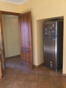 uma cozinha com um frigorífico ao lado de uma porta em Villa La Scogliera em Acireale