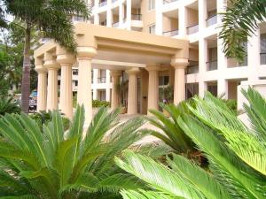 un bâtiment avec des palmiers en face de celui-ci dans l'établissement Palazzo Colonnades, à Gold Coast