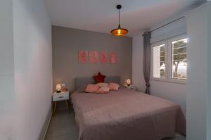 a bedroom with a bed with pink pillows on it at Edificio Thader - Ciudad Quesada in Ciudad Quesada