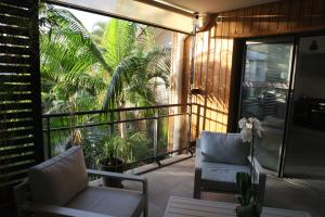 d'un balcon avec deux chaises et une vue sur les palmiers. dans l'établissement 100 rue Suffren, à Saint-Pierre