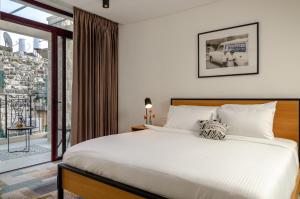1 dormitorio con 1 cama grande y balcón en Biazi Hotel, en Jerusalén