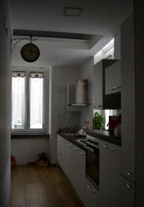 Una cocina con gabinetes blancos y un horno de estufa. en Le 13 Fontane, en Salerno