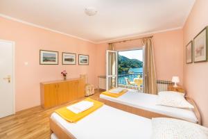 a bedroom with two beds and a window at House Ljilja in Rogotin