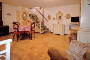 sala de estar con mesa y sillas y escalera en Casa Morellini en Ortonovo