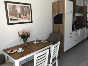 een kleine tafel in een keuken met een tafel en stoelen bij Ferienwohnung Zweisamkeit in Graal-Müritz