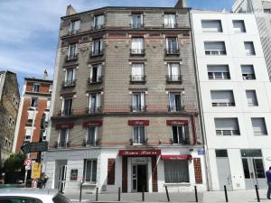 a tall brick building on the corner of a street at Hôtel Moderne in Saint-Denis
