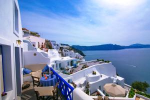 a view of the ocean from a balcony with white buildings at Ifestio Villas Oia in Oia