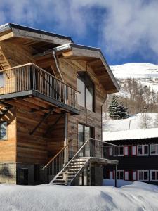 a log building with stairs in the snow at Le Chalet des Boisses, Luxury Ski-In Ski-Out Chalet for 12 in Tignes
