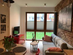 a living room with a couch and a brick wall at apartamenty Stary Kraków GO in Kraków