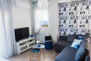 a living room with a couch and a tv at Sea Breeze Experience in Kavála