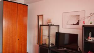 a living room with a tv and a wooden cabinet at Ruhiges Zimmer Nähe Nürnberg Messe mit Wallbox in Nuremberg